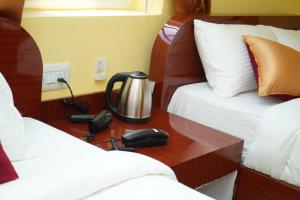 uma secretária num quarto com 2 camas e um telefone em H2 Residency em Ramanathapuram