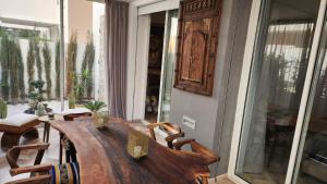 a dining room with a wooden table and chairs at Studio Haut standing Casa finance City Tour Vegetale Yasmine Signature Résidence in Casablanca