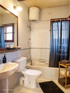 a bathroom with a toilet and a sink and a tub at IL Gnejna II in Xagħra