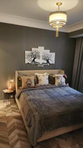ein Schlafzimmer mit einem großen Bett und einem Kronleuchter in der Unterkunft Studio Haut standing Casa finance City Tour Vegetale Yasmine Signature Résidence in Casablanca