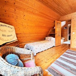 Habitación con cama y sillas de mimbre en una cabaña en Lootuse Spa en Nõmmemaa