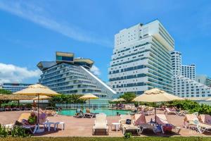 basen z leżakami i parasolami oraz niektóre budynki w obiekcie Fabulous Oceanview Suite with Private Jacuzzi plus Access to Beach&Pools w mieście Cancún