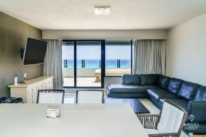 salon z kanapą i stołem z krzesłami w obiekcie Fabulous Oceanview Suite with Private Jacuzzi plus Access to Beach&Pools w mieście Cancún