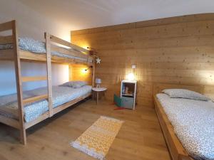 Una habitación con dos literas y un televisor. en LE ZÈDÈL - Duplex 100m2 vue montagne, au cœur de la Savoie, au pied des stations de ski, en Aigueblanche