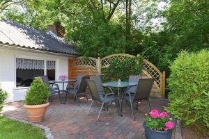 旺格兰Ferienwohnungen Janssen-Graalfs的有桌椅和树木的露台
