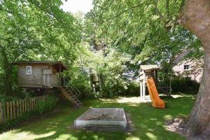 旺格兰Ferienwohnungen Janssen-Graalfs的后院设有带滑梯和树的游乐场