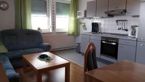 uma cozinha e sala de estar com um sofá e uma mesa em Ferienwohnungen Conerus em Carolinensiel
