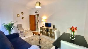 a living room with a blue couch and a table at Chiado Apartment with Terrace 1 in Lisbon