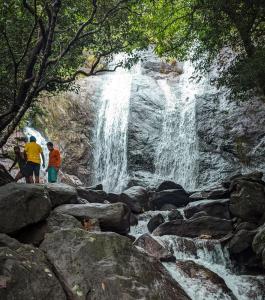 two people standing in front of a waterfall at Wild Jacket in Vagamon