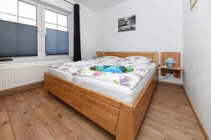 1 dormitorio con cama de madera en una habitación con ventana en Ferienwohnung Möwe, en Carolinensiel