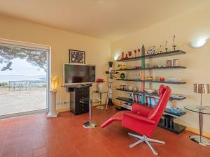 ボルム・レ・ミモザにあるHoliday Home Jalna - BOM120 by Interhomeのリビングルーム(赤い椅子、テレビ付)