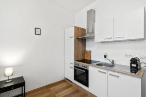 - une cuisine avec des placards blancs et un évier dans l'établissement StayEasy Apartments Vienna A#3, à Vienne