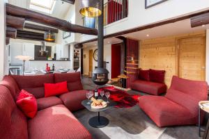 a living room with red couches and a fireplace at Chalet des Cimes - Chamonix All Year in Chamonix