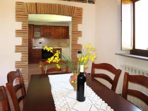 una sala da pranzo con tavolo e bottiglia di vino di Apartment Fienile by Interhome a Sasso Pisano