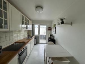 Una cocina con gabinetes blancos y una mesa en ella. en Luxembourg city appartement 105m2 with balcony, en Luxemburgo 11 fotos más