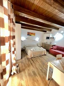 ein Schlafzimmer mit einem Bett und einem roten Sofa in der Unterkunft 67 Rooms in Cefalú