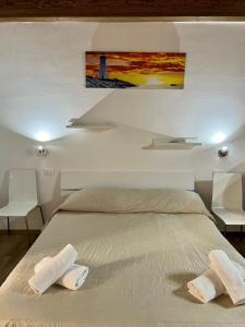 ein Schlafzimmer mit einem Bett mit zwei Handtüchern darauf in der Unterkunft 67 Rooms in Cefalú