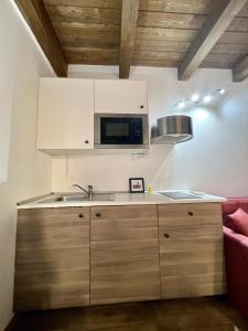 eine Küche mit einer Spüle und einer Mikrowelle in der Unterkunft 67 Rooms in Cefalú