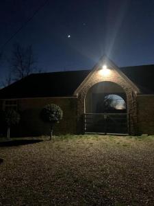 a house with a light on the side of it at night at Chillout!! Sussex Flint Cottage- HotTub - Goodwood in Eartham