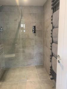 a bathroom with a shower with a tiled shower at Chillout!! Sussex Flint Cottage- HotTub - Goodwood in Eartham