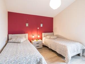 duas camas num quarto com paredes vermelhas em Gîte Saint-Julien-de-Concelles, 4 pièces, 6 personnes - FR-1-306-815 em Saint-Julien-de-Concelles