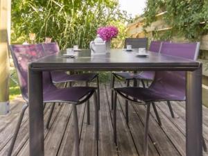 a black table and purple chairs on a deck at Charmante maison rénovée à 300m de la Loire avec jardin, terrasse, WiFi et équipements bébé - FR-1-306-815 in Saint-Julien-de-Concelles