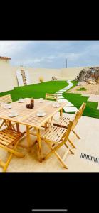 a wooden table with two chairs and a table with plates at APARTAMENTO RURAL MIRADOR DE SIERRA BERMEJA in Mirandilla