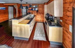a kitchen in a log cabin with wooden walls at 4 Bedroom Beautiful Home In Rysstad in Rysstad