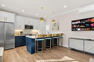 a kitchen with stainless steel appliances and blue bar stools at Caviar Dreams In The Heart of Hillcrest in San Diego