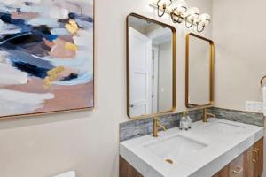 un baño con lavabo y una pintura en la pared en Caviar Dreams In The Heart of Hillcrest en San Diego