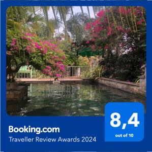 a swimming pool in a garden with pink flowers at B&B Verger Vannary 