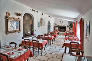 a restaurant with red tables and chairs and a fireplace at Clamador in Saintes-Maries-de-la-Mer
