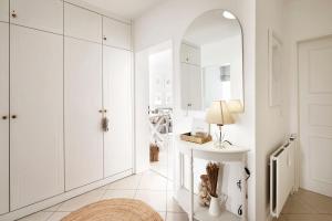 La salle de bains blanche est pourvue d'un lavabo et d'un miroir. dans l'établissement Wohnen am Südstrand 01, à Wyk auf Föhr