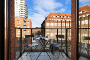 a balcony with two chairs and a table on it at Elite Apartments Wałowa Studio in Gdańsk