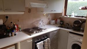 a kitchen with a stove top oven next to a sink at Spacious double bedroom in quiet house with garden view in Dublin