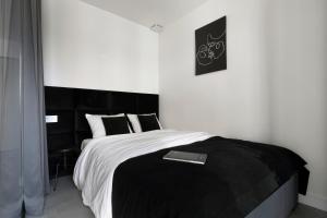 - une chambre avec un lit et une couverture noire et blanche dans l'établissement Elite Apartments Wałowa Studio, à Gdańsk