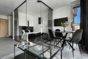 a living room with a glass table and a bed at Elite Apartments Wałowa Studio in Gdańsk