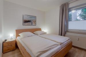 ein Schlafzimmer mit einem großen Bett und einem Fenster in der Unterkunft Wohnen am Südstrand 02 in Wyk auf Föhr