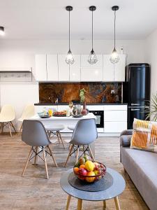 eine Küche und ein Wohnzimmer mit einem Tisch und einer Obstschale in der Unterkunft 31_Vezuvio - DeerRest Apart in Jelenia Góra