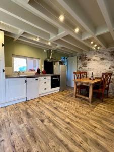 Una gran cocina con una mesa de madera y un suelo de madera. en Le Clos Marin cottage proche Deauville, en Cricquebœuf