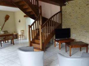 a living room with a wooden staircase and a tv at Gîte Saint-Gervais-en-Belin, 3 pièces, 6 personnes - FR-1-410-146 in Saint-Gervais en-Belin