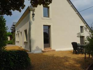 a white house with a table and chairs in the yard at Gîte familial avec jardin et vélos, proche Le Mans - FR-1-410-146 in Saint-Gervais en-Belin