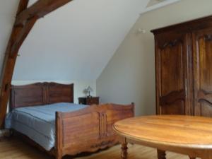 a bedroom with a bed and a wooden table at Gîte familial avec jardin et vélos, proche Le Mans - FR-1-410-146 in Saint-Gervais en-Belin +3 photos