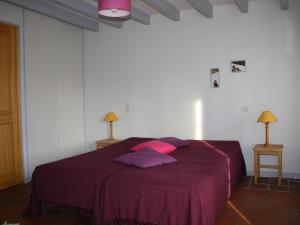a bedroom with a bed with purple sheets and two lamps at Gîte Saint-Rémy-de-Sillé, 6 pièces, 8 personnes - FR-1-410-150 in Saint-Rémy-de-Sillé