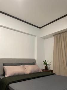 a white bedroom with a bed and a window at Affordable Tourist Studio Condo near Mactan Airport by A&C in Pusok +11 photos
