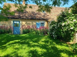 una casa con un giardino verde fiorito di Charmante maison paysanne rénovée avec grand terrain, proche de la rivière et du village médiéval - FR-1-410-162 a Asnières-sur-Vègre