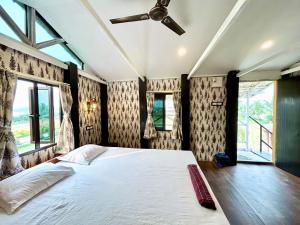 Palli Bangla Resort, near Ruby Hospital, Anandapur في كولْكاتا: غرفة نوم بسرير ومروحة سقف