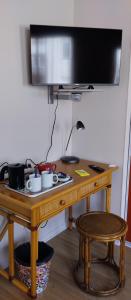 einen Holzschreibtisch mit einem TV an der Wand in der Unterkunft Chambre 20 m2 S de B WC privés Terrasse Garage in Lyon
