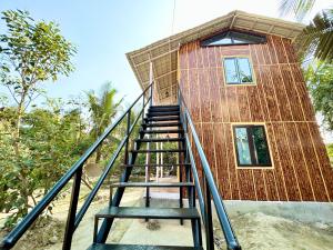 a building with a staircase leading up to it at Palli Bangla Resort, near Ruby Hospital, Anandapur in Kolkata