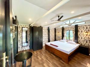 Palli Bangla Resort, near Ruby Hospital, Anandapur في كولْكاتا: غرفة نوم بسرير كبير في غرفة